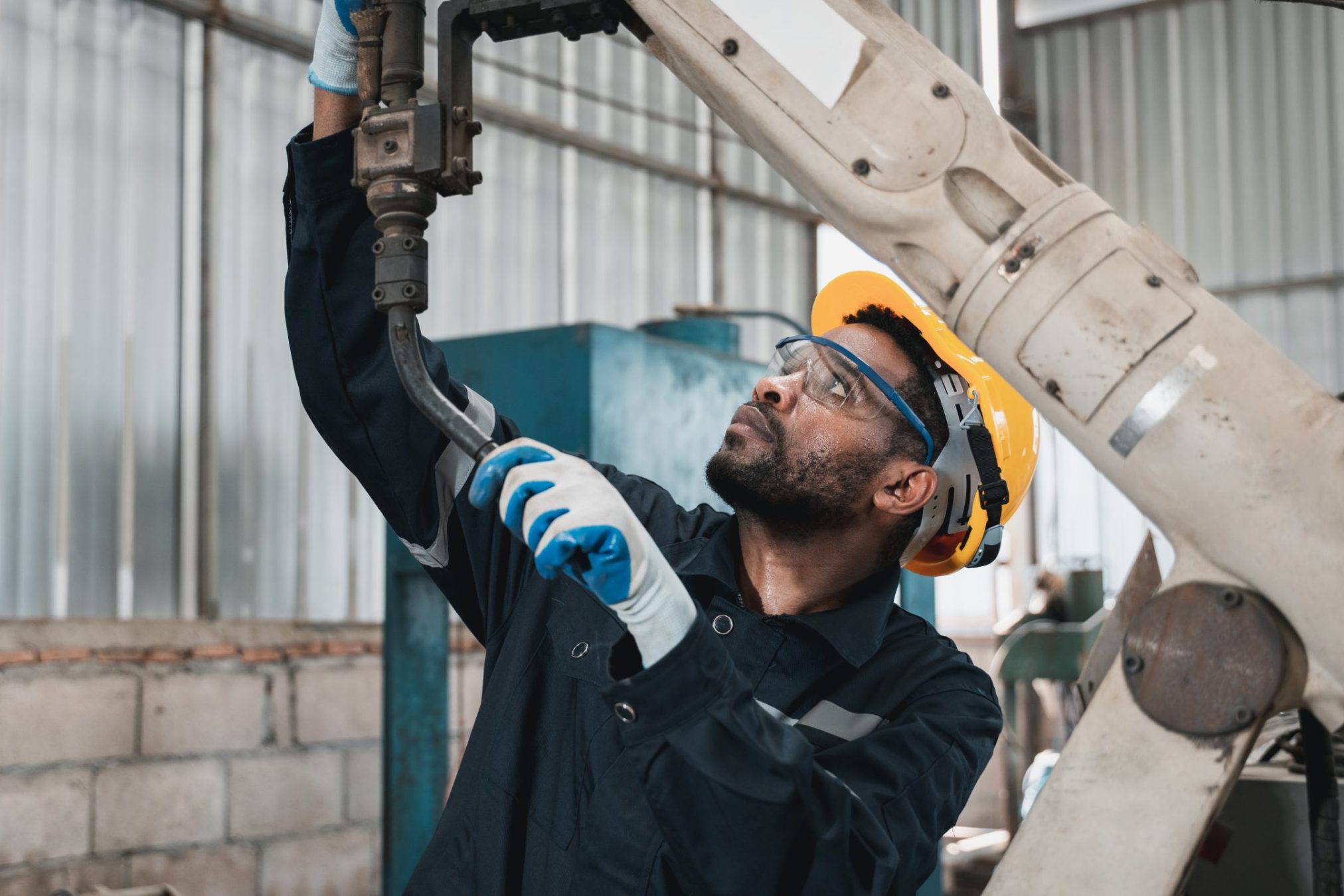 Industrial engineers is in charge of controlling the automated robot arms machine welding robots in industrial manufacturing factory.